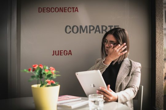 Mujer con una tableta digital mientras habla por teléfono